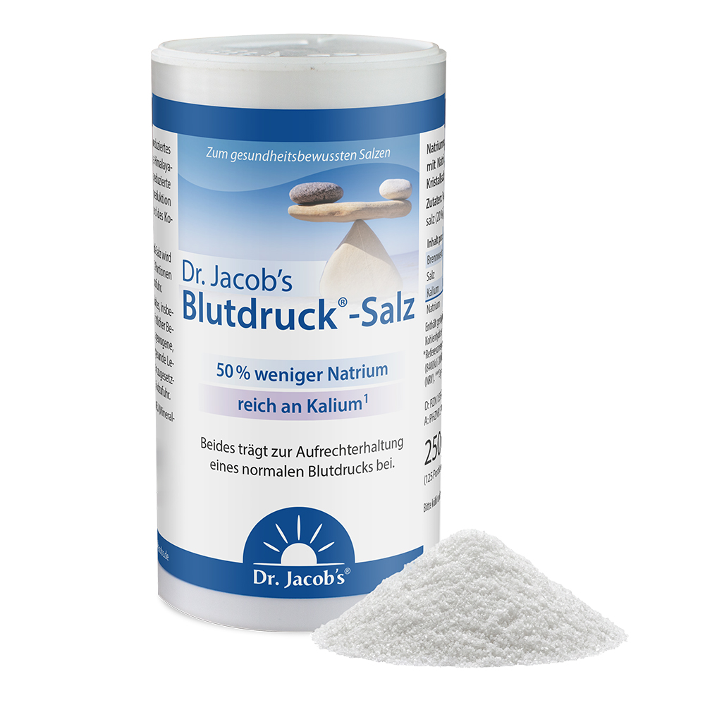 Dr. Jacob's Blutdruck-Salz in einem 250-g-Shaker-Behälter, mit einem Etikett mit einer Steinbalance-Grafik, die 50 % weniger Natrium und einen hohen Kaliumgehalt hervorhebt, begleitet von einem kleinen Haufen weißer Salzkristalle im Vordergrund.