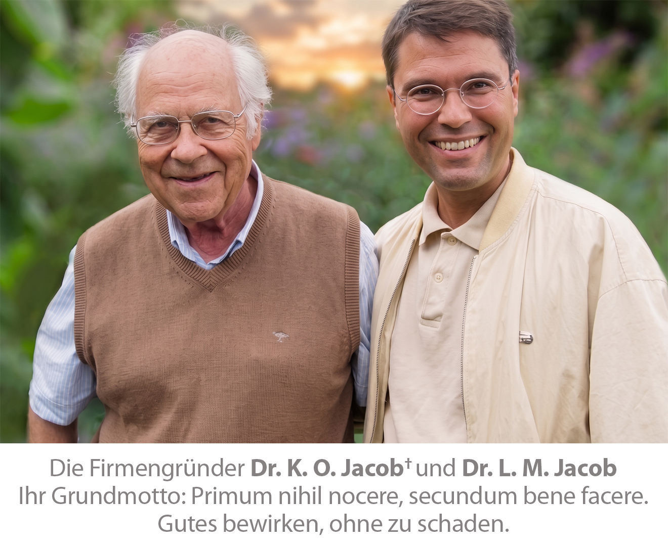 Porträt der Firmengründer Dr. K. O. Jacob und Dr. L. M. Jacob, die gemeinsam im Freien vor einem verschwommenen Gartenhintergrund stehen und die Philosophie repräsentieren, Gutes zu tun, ohne Schaden anzurichten.